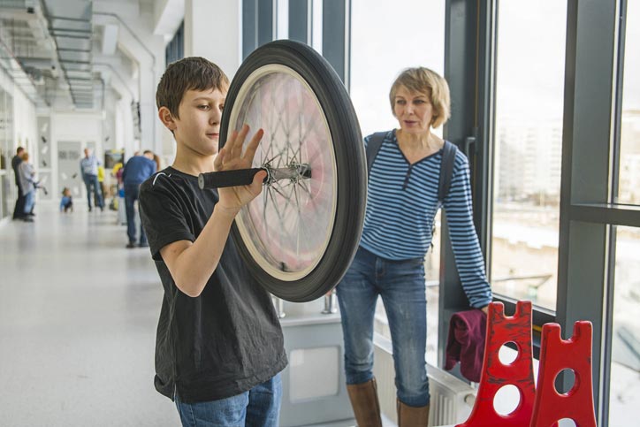 An image of a young boy visiting a science museum with a family member