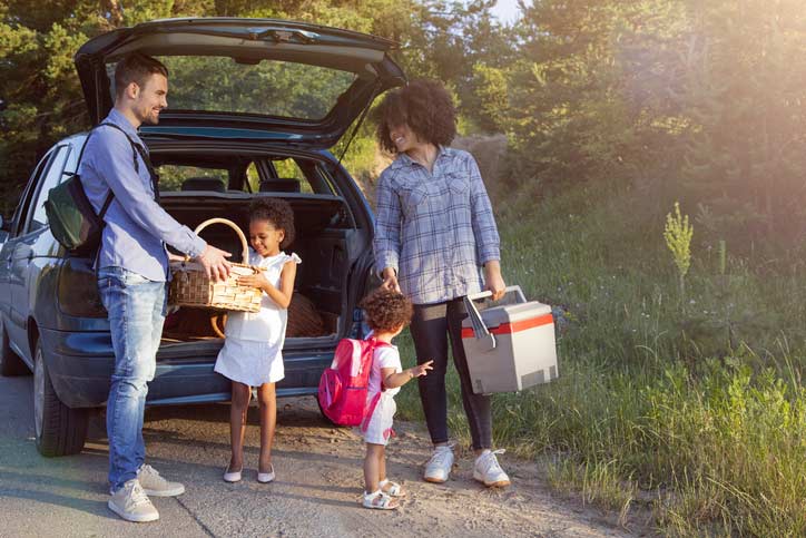 Image of a family unloading the car and getting ready to have an outdoor picnic