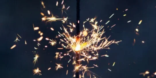Golden hued fireworks going off in the night sky as the new year arrives,