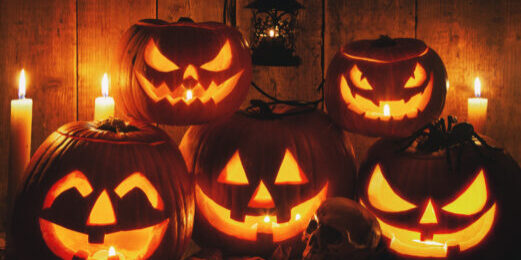 Halloween Jack-o-Lantern Pumpkins on rustic wooden background