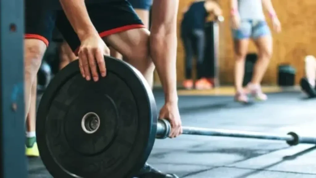 A man grabbing weights at the gym for his workout.