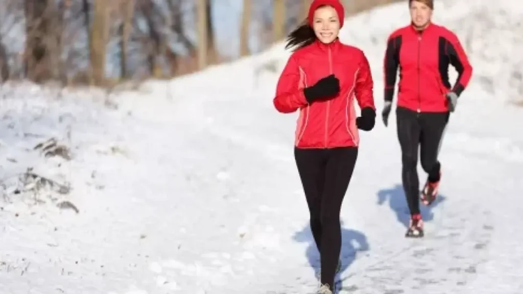 A woman and a man race though snow during the wintertime.